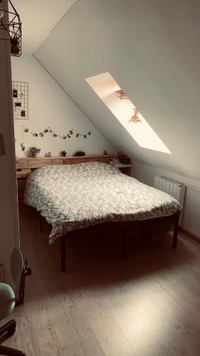 une chambre avec un lit dans un grenier dans l'établissement Maison La Suze, à La Suze-sur-Sarthe