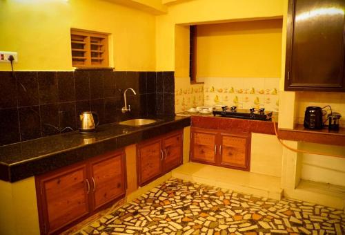 a kitchen with wooden cabinets and a sink at New Heaven Group accommodation in Thekkady