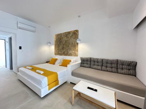 Zimmer mit 2 Betten, einem Sofa und einem Tisch in der Unterkunft Ladiko Inn Hotel Faliraki -Anthony Quinn Bay in Faliraki