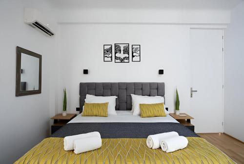 Un dormitorio con una cama grande con dos almohadas. en Paradise+ With Jacuzzi In the heart of Athens!, en Atenas