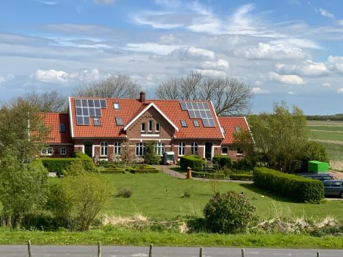 a house with solar panels on its roof at Ferienwohnungen Zollhaus Utlandshoern in Norden