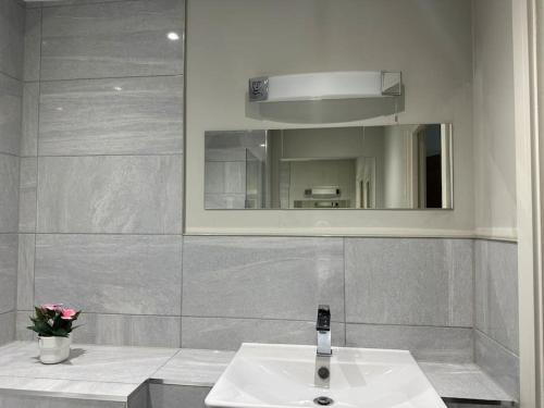 y baño con lavabo y espejo. en Bright, spacious 1 bedroom flat, en Brentwood
