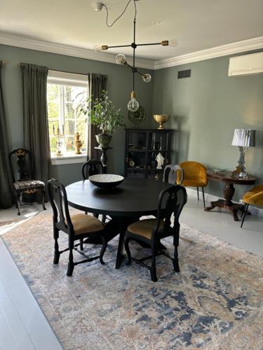 a dining room with a black table and chairs at Ladegaarden in Skien