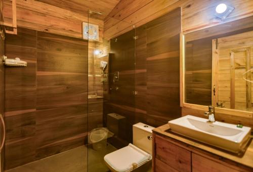 een badkamer met een wastafel, een toilet en een douche bij Tashree Kabeela Riverside Resort in Marchula