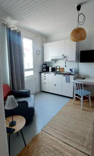 a living room with a couch and a kitchen at Apartment Lintu in Mikkeli