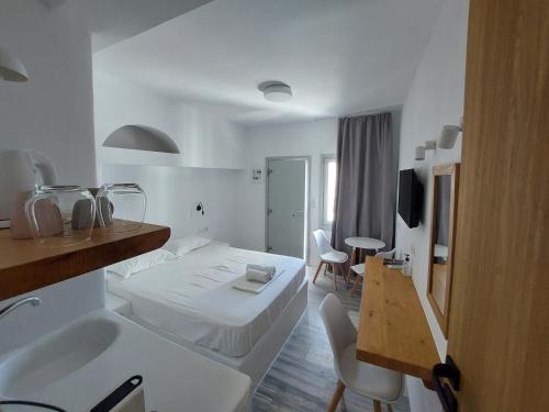 a white room with a bed and a sink at Castellino Naxos in Naxos Chora