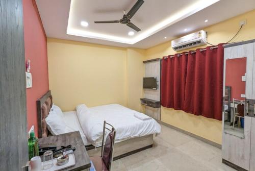 una camera ospedaliera con un letto e una tenda rossa di GRG TRS Inn Ranchi a Rānchī