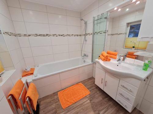 un bagno con vasca, lavandino e doccia di Natur & Wellness Ferienhaus Garden a Siedlung Bergheide