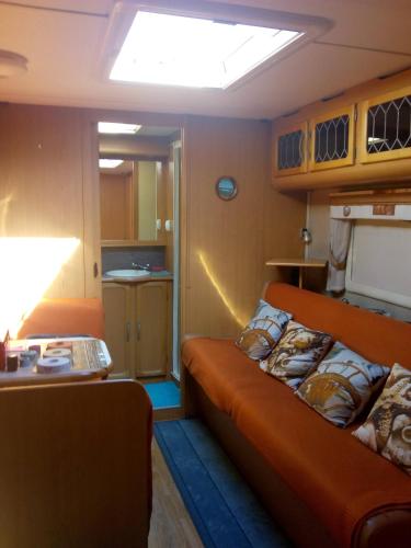 uma sala de estar com um sofá laranja num quarto em Asuntovaunu majoitus em Himanka