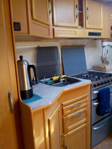 uma cozinha com um fogão e um lavatório num trailer em Asuntovaunu majoitus em Himanka