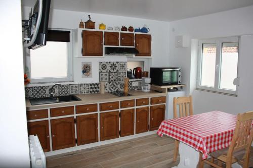 - une cuisine avec des placards en bois, une table et un four micro-ondes dans l'établissement La maisonnette de Jean BAR à Thun-Saint-Martin, à Thun-Saint-Martin