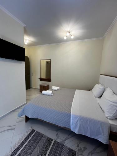 1 dormitorio con 1 cama grande y 2 toallas. en Oscar’s Apartments Drymades, en Dhërmi