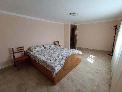 ein Schlafzimmer mit einem Bett und einem Stuhl in der Unterkunft Hotel Giurgiulesti 