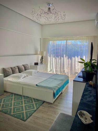 une chambre avec un grand lit et une grande fenêtre dans l'établissement Sunny Riviera Apartment, à Nice
