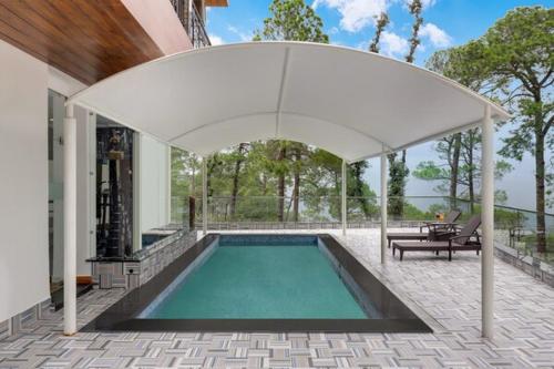 a swimming pool under an umbrella in a house at Lemon Tree Hotel, Mcleodganj in McLeod Ganj