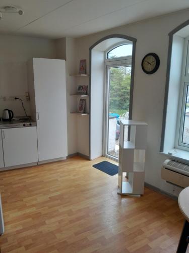 une chambre vide avec une cuisine et une grande fenêtre dans l'établissement Apartment mit Balkon im Herzen von Høyer, à Højer