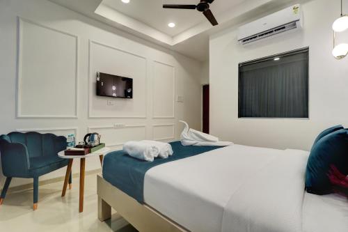 ein Schlafzimmer mit einem Bett, einem Stuhl und einem TV in der Unterkunft Hotel Aura Dombivali in Dive