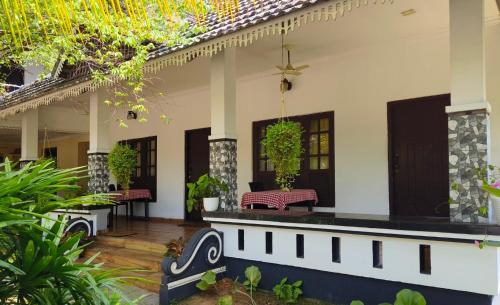 a patio of a house with benches and plants at Marari Blue Waves in Mararikulam