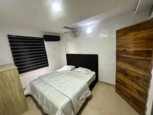 a small bedroom with a bed and a wooden door at Port punta in Lekki