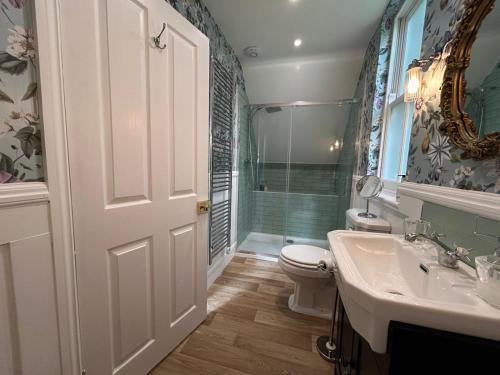 a bathroom with a toilet and a sink and a shower at Ashleigh Buxton in Buxton