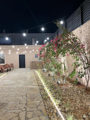 un patio con flores al lado de un edificio en شاليهات حائط طيني, en Riad