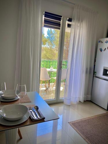 - une cuisine avec une table, des verres et un réfrigérateur dans l'établissement Sunny Riviera Apartment, à Nice