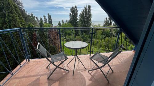 a balcony with a table and two chairs at Levendulás in Szigliget