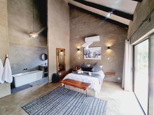um quarto com uma cama grande e uma banheira em Rhino's Rest Luxury Villa em Hoedspruit