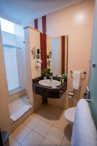 a bathroom with a sink and a shower and a toilet at Ayass Hotel in Amman