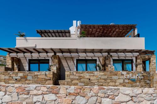 a building on top of a stone wall at Lalari Beach Suites in Vari
