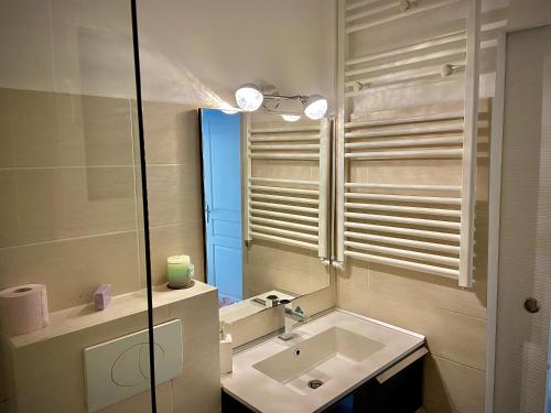 une salle de bain avec un lavabo et un miroir dans l'établissement Sunny Riviera Apartment, à Nice
