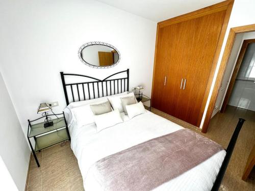 une chambre avec un grand lit et un miroir dans l'établissement RelaxMaria, à Sant Carles de la Ràpita