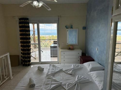 1 Schlafzimmer mit einem weißen Bett und einem Balkon in der Unterkunft Villa Sophia in Loutraki
