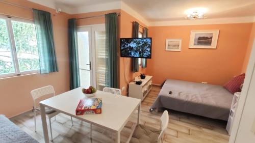 ein Wohnzimmer mit einem Tisch und einem Bett in der Unterkunft Bonrila Sun Apartman in Zamárdi