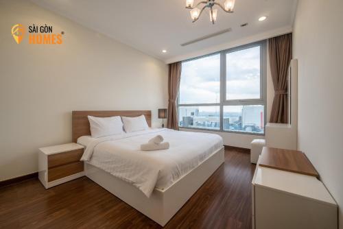 a bedroom with a bed and a large window at Vinhomes CenTral Park Saigon in Ho Chi Minh City