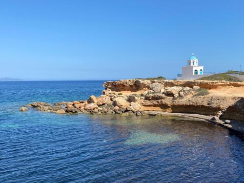 a lighthouse on the shore of a body of water at Artemis Boutique House in Artemida