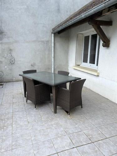 une table noire et des chaises sur une terrasse dans l'établissement La p tite maison, à Gien