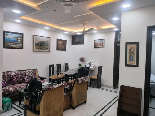 een wachtkamer met banken en een tafel en stoelen bij YANA B&B in New Delhi