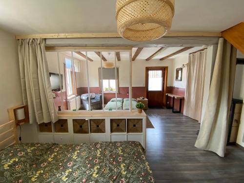 une chambre avec un lit et un grand miroir dans l'établissement Calme et cosy - village viticole - route du vin, à Traenheim