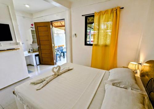 a bedroom with a bed with a ribbon on it at Astillo's Guest Houses in Moalboal