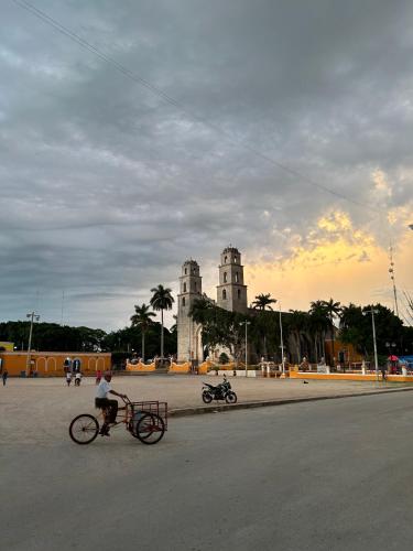 a person riding a bike in front of a building at Casona los Cedros in Espita