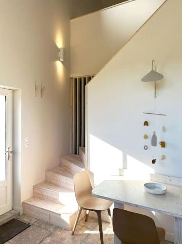 une pièce avec une table, des chaises et un escalier dans l'établissement La slow home, à Beaune