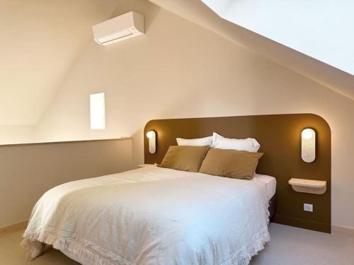 une chambre avec un grand lit dans un grenier dans l'établissement La slow home, à Beaune