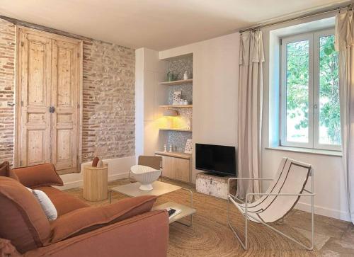 un salon avec un canapé et une télévision dans l'établissement La slow home, à Beaune