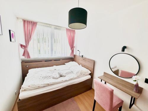 een slaapkamer met een bed, een bureau en een spiegel bij Roma in Duszniki Zdrój