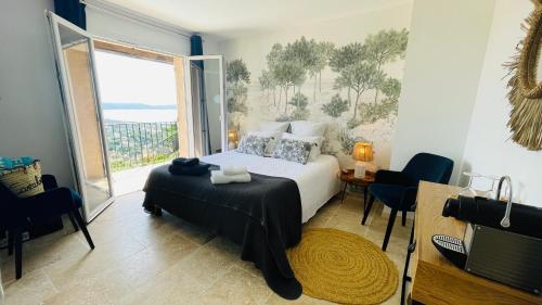 um quarto com uma cama e uma grande janela em Villa Cacharelle Vue Mer em Cavalaire-sur-Mer