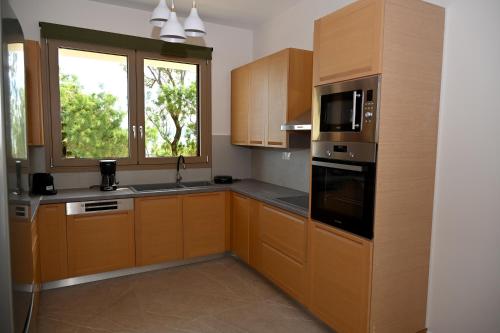 a kitchen with wooden cabinets and a window at Koumpis Residences in Chios