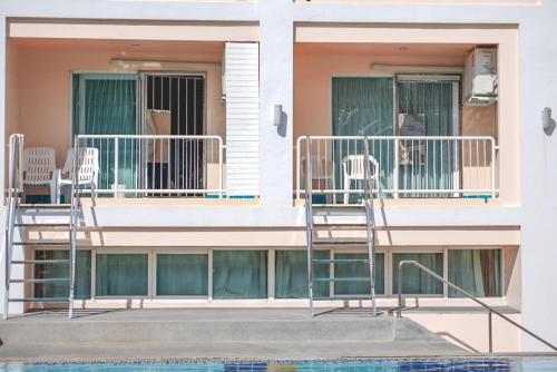 a building with two chairs and a balcony at Best Bella Pattaya in Pattaya North