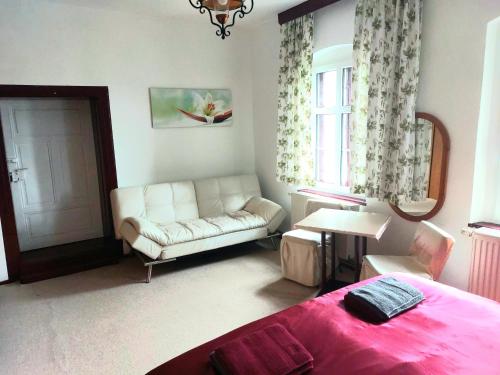 a bedroom with a bed and a couch and a window at Gasthof Oberschmiede in Auf der Wiese