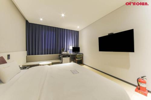 a hotel room with a bed and a flat screen tv at Chungjangro Ilbeonji Boutique Hotel in Gwangju